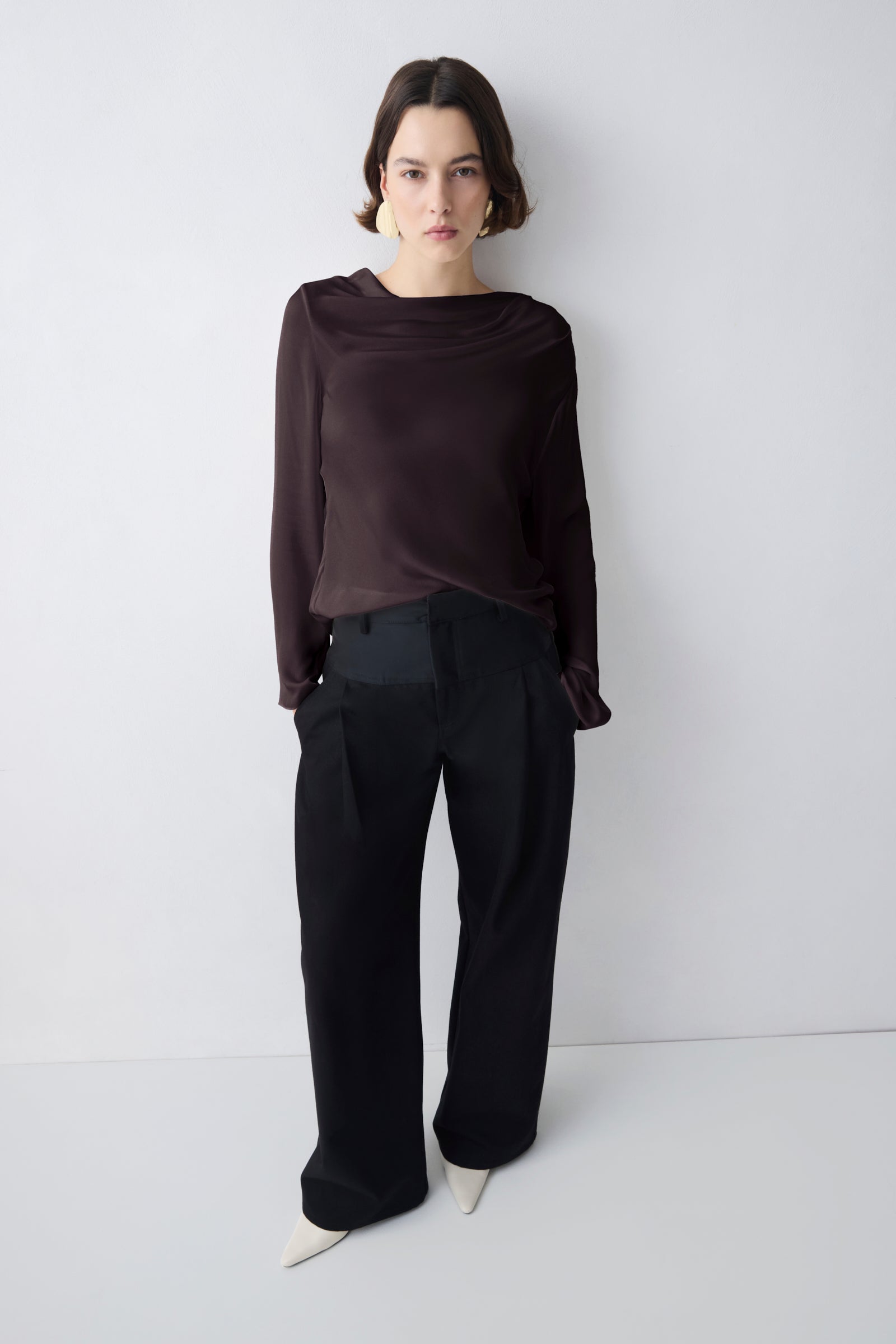 Person wearing a brown outfit against a white background