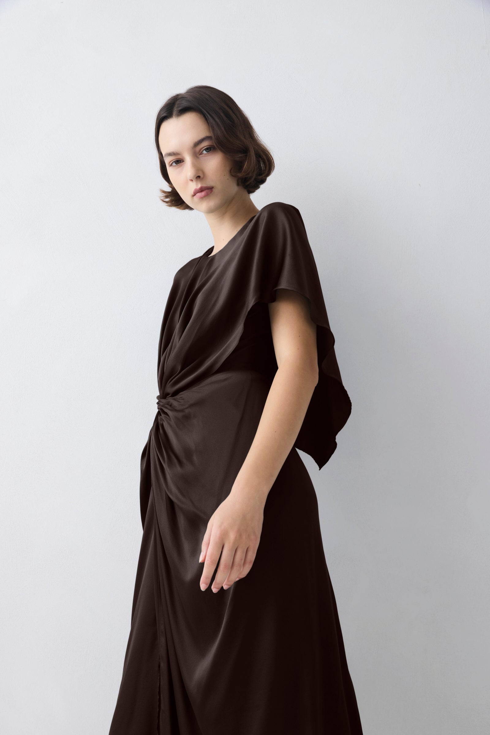 Woman wearing a black dress against a white background