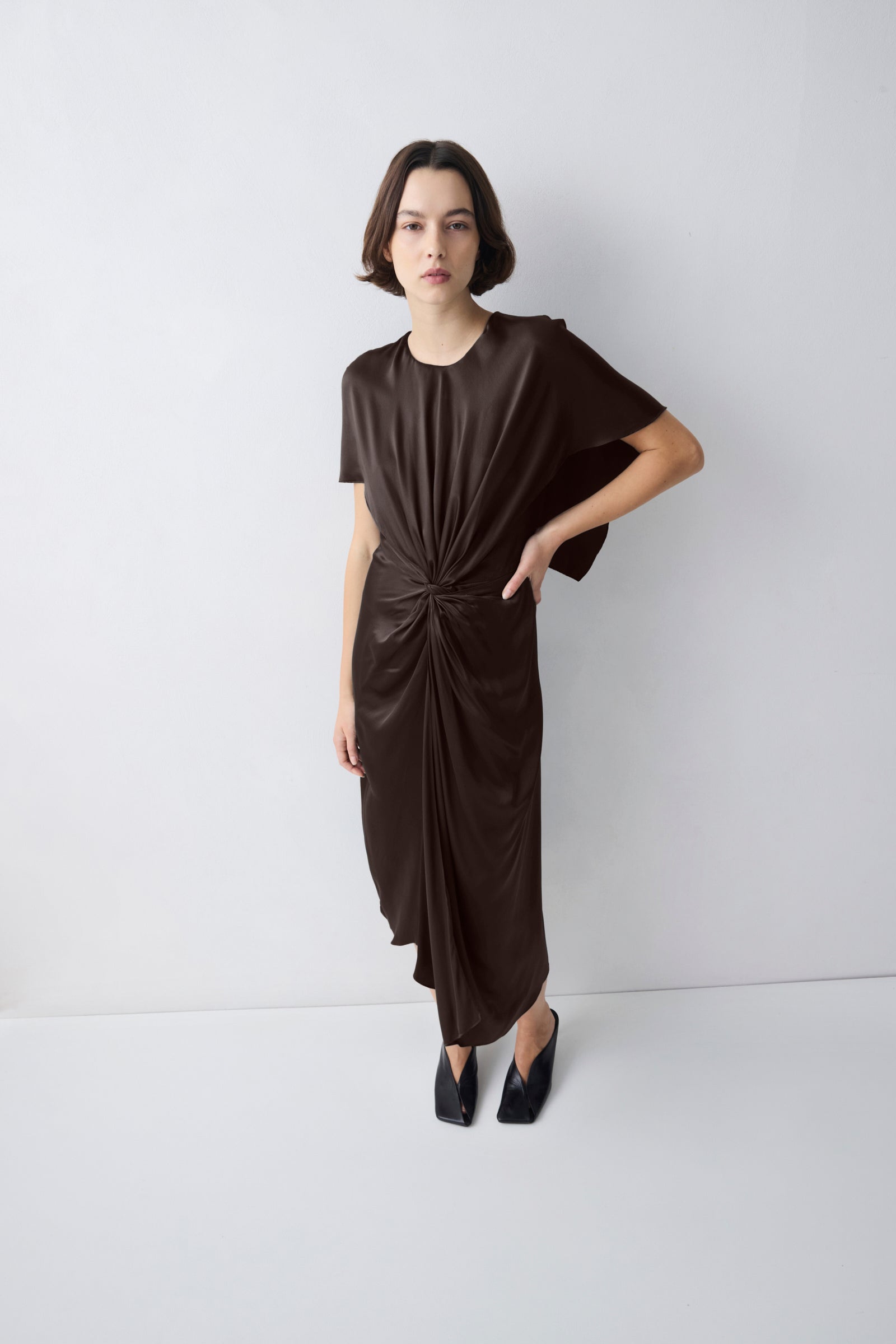 Woman wearing a brown dress against a white background