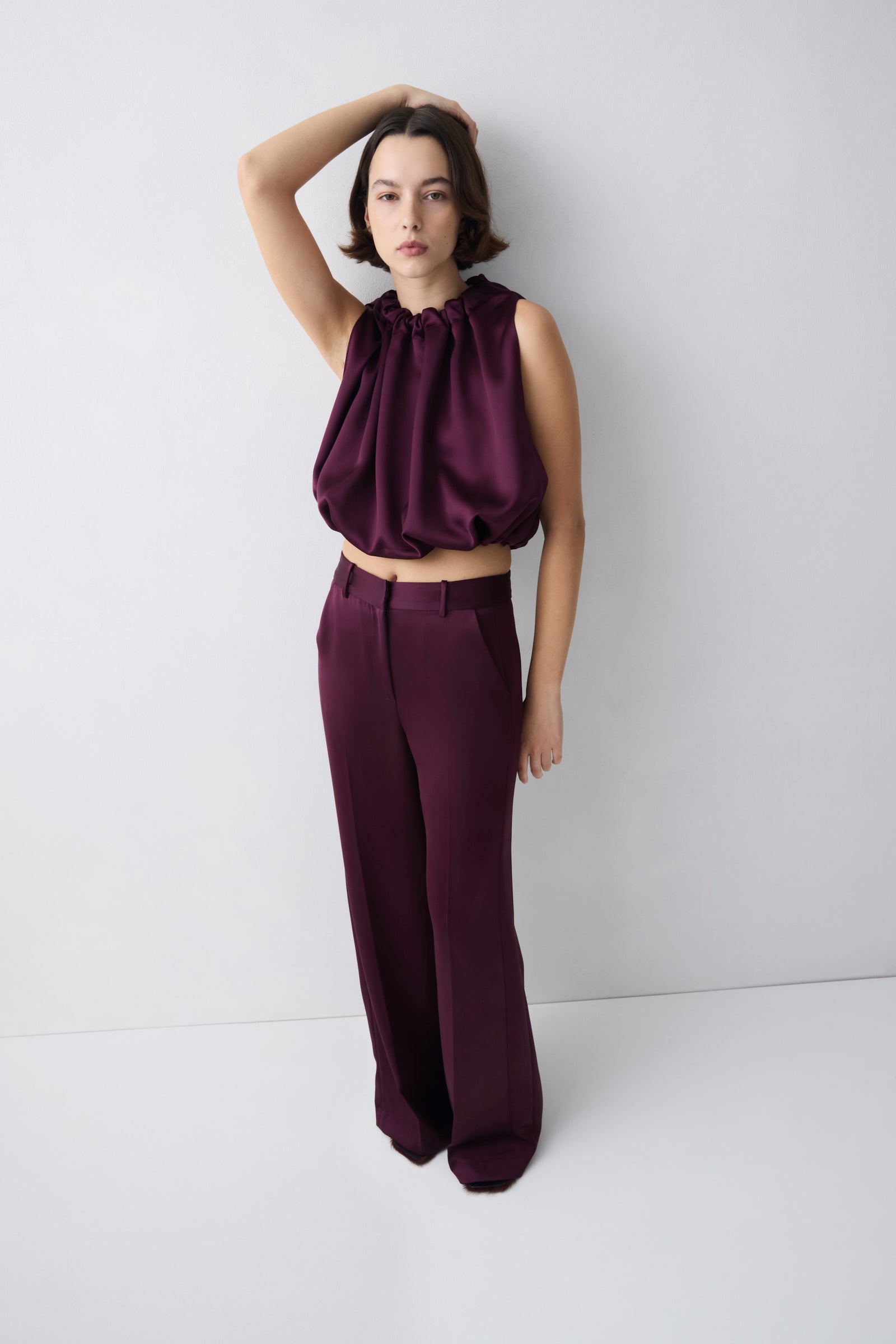 Plum satin sleeveless top with sculptural draped silhouette