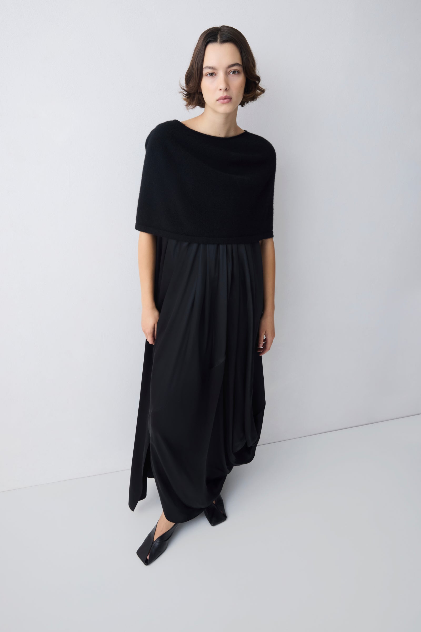 Woman wearing a black dress against a white background