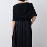 Person wearing a black dress against a white background