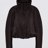 A black cropped jacket with a high stand-up collar and long sleeves, shown against a plain light gray background.