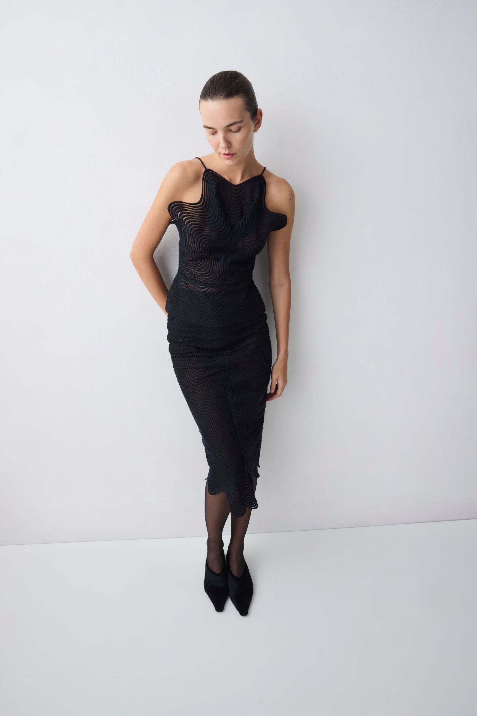 Woman wearing a black dress against a white background