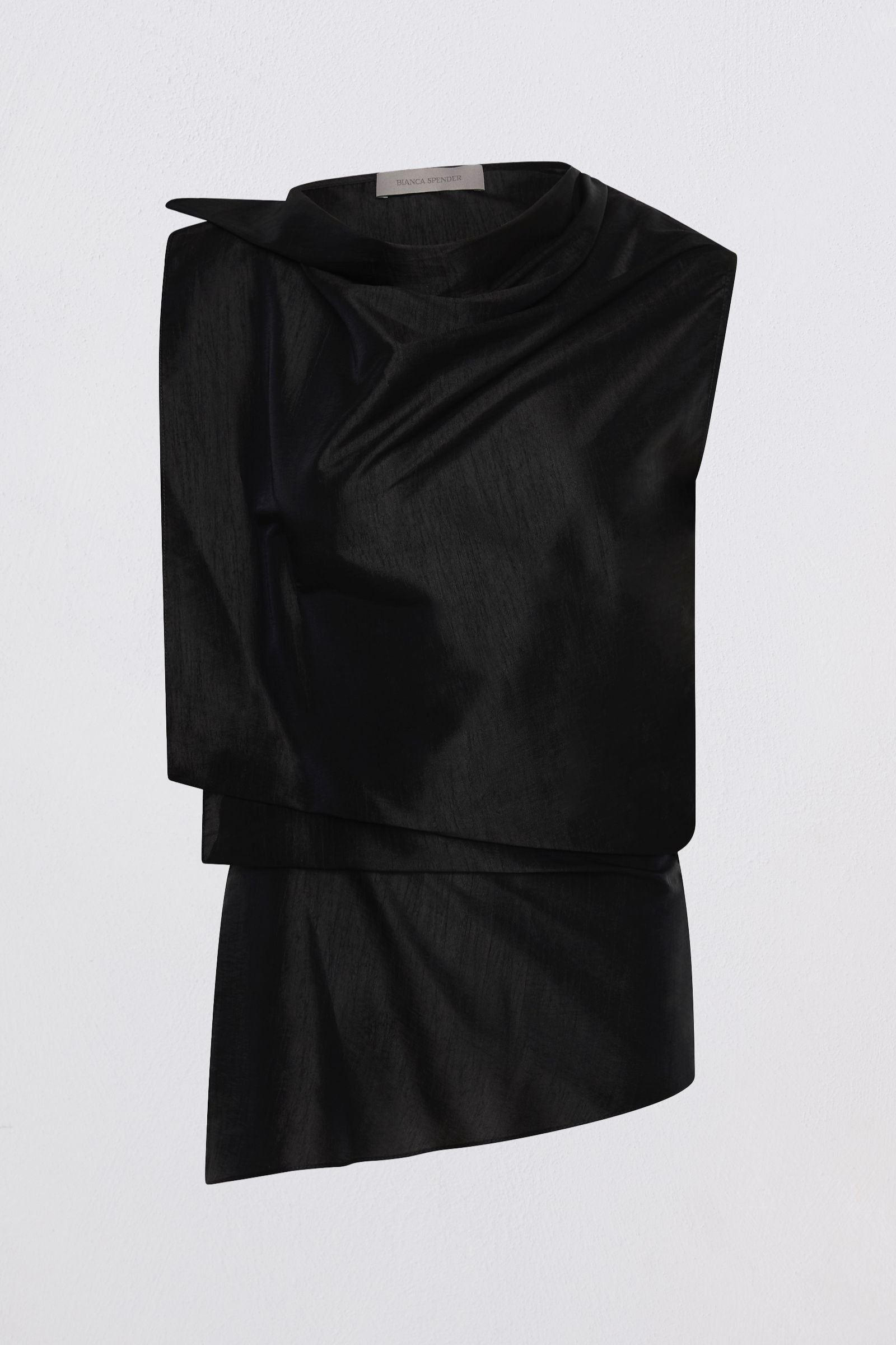 A black draped asymmetrical top with a high mock neck and layered ruffle details, shown against a plain light gray background.