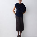 Person wearing a dark blue top and black skirt on a white background