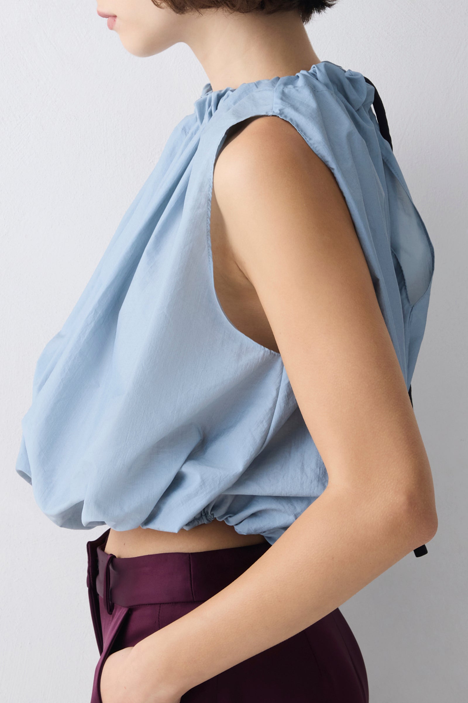Light blue sleeveless top worn by a person on a plain background