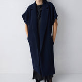 Woman wearing a long navy blue dress against a white background