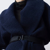 Navy blue jacket with a belt on a plain background