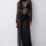 Woman wearing a black lace dress against a white background
