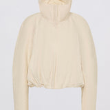 A cropped, long-sleeve jacket in a light cream or off-white color, featuring a high stand-up collar and a gathered, quilted design, shown against a plain light gray background.