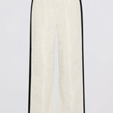 Off-white wide-leg pants with black side stripes, shown flat against a light gray background.