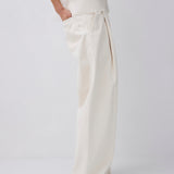 Person wearing white pants on a plain background