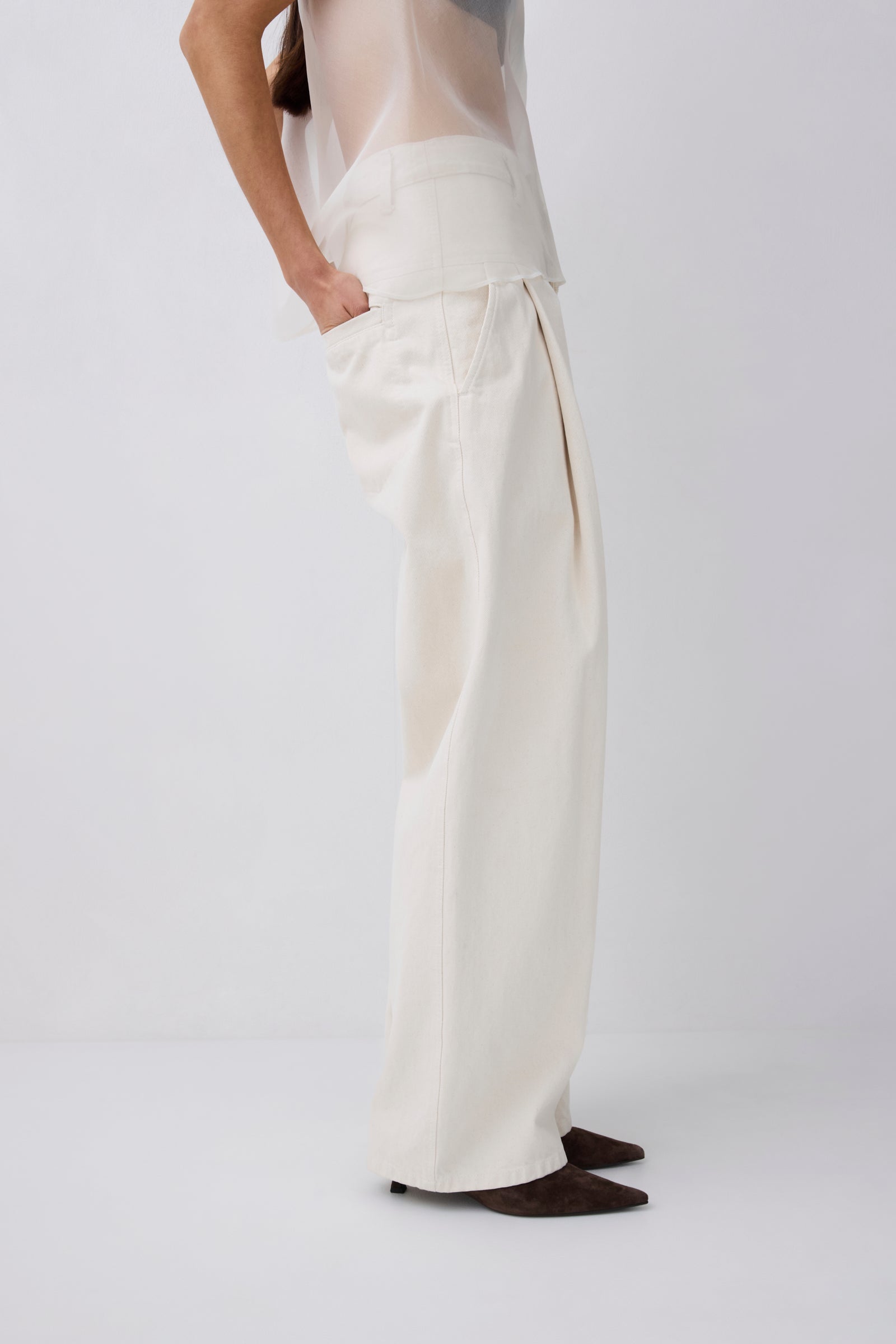 Person wearing white pants on a plain background