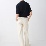 Person wearing a black shirt and white pants on a white background