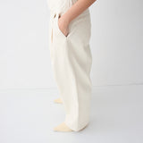Person wearing white pants and a black top on a white background
