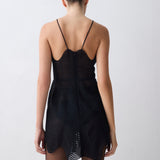 Black sleeveless dress with wavy pattern on a plain background