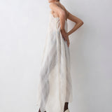 Woman wearing a strapless dress with a geometric pattern against a white background
