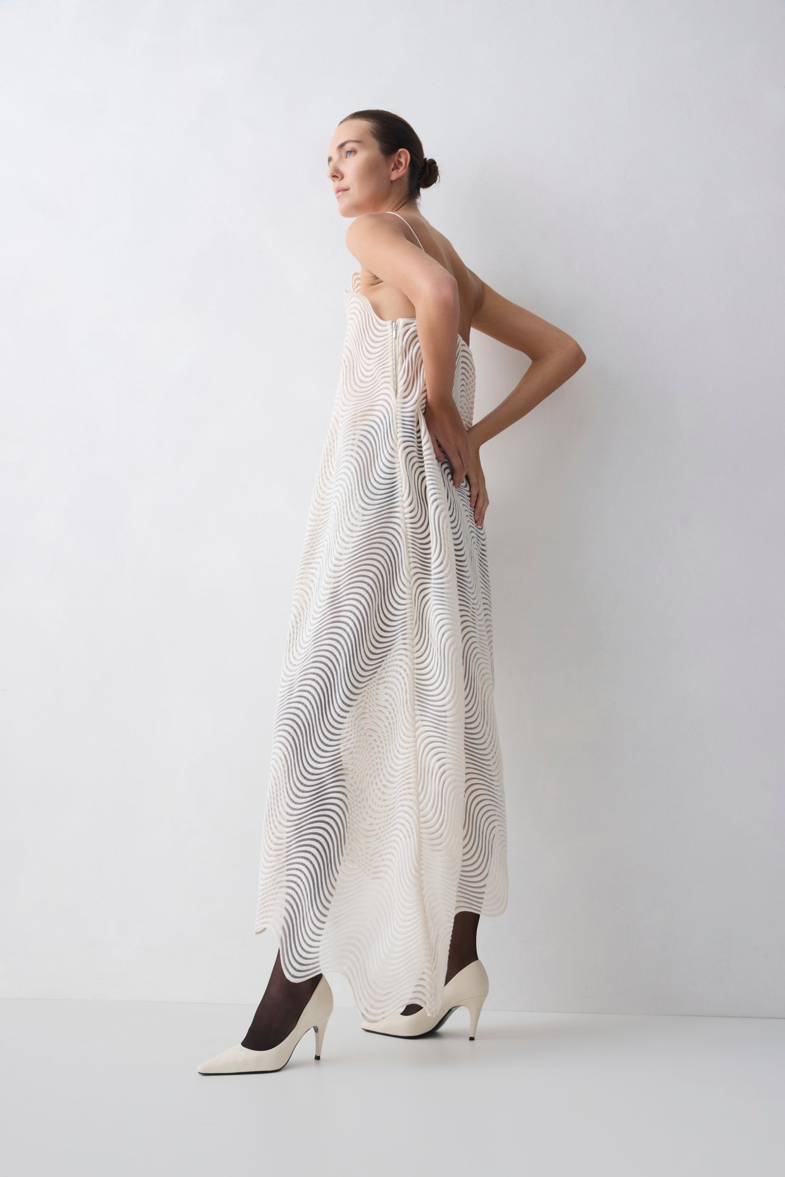Woman wearing a strapless dress with a geometric pattern against a white background