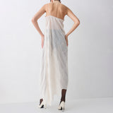 Woman wearing a long, light-colored dress with a subtle pattern on a white background