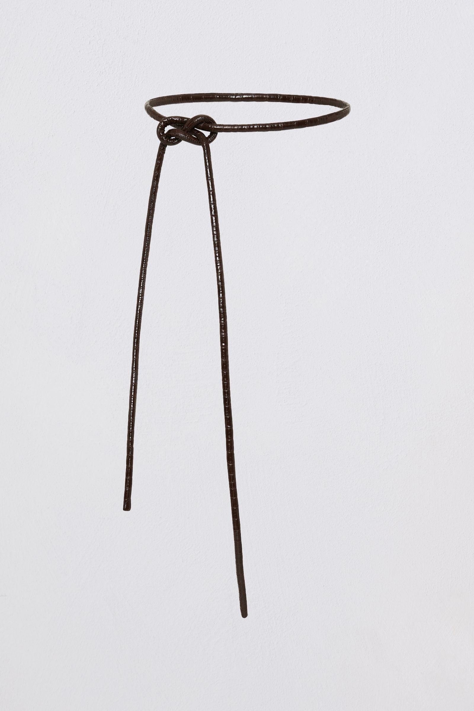 A dark brown textured leather belt with a simple circular loop and a small knot at the front, displayed against a solid light gray background.