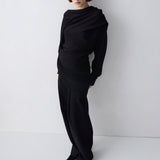 Person wearing a black outfit against a white background