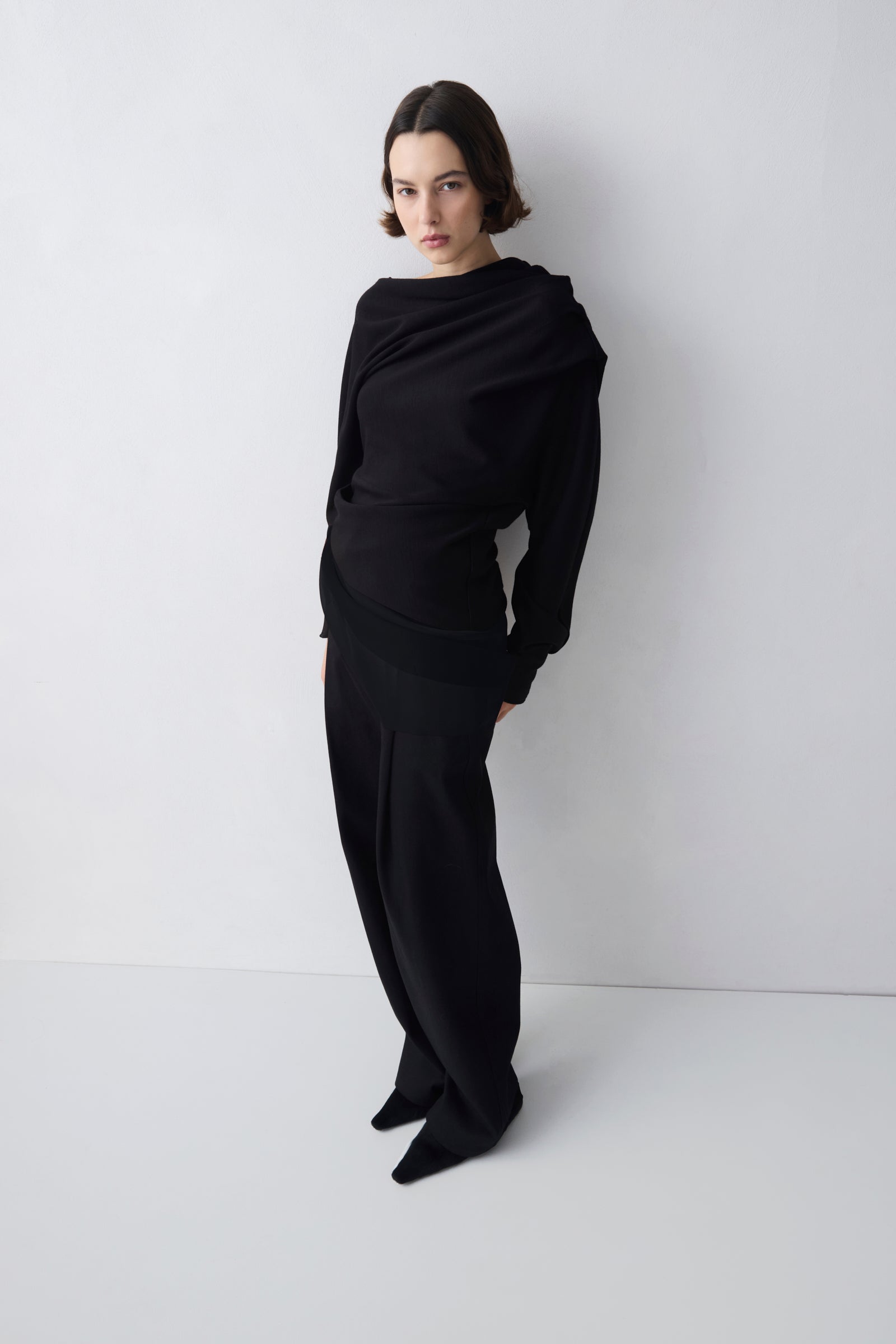 Person wearing a black outfit against a white background