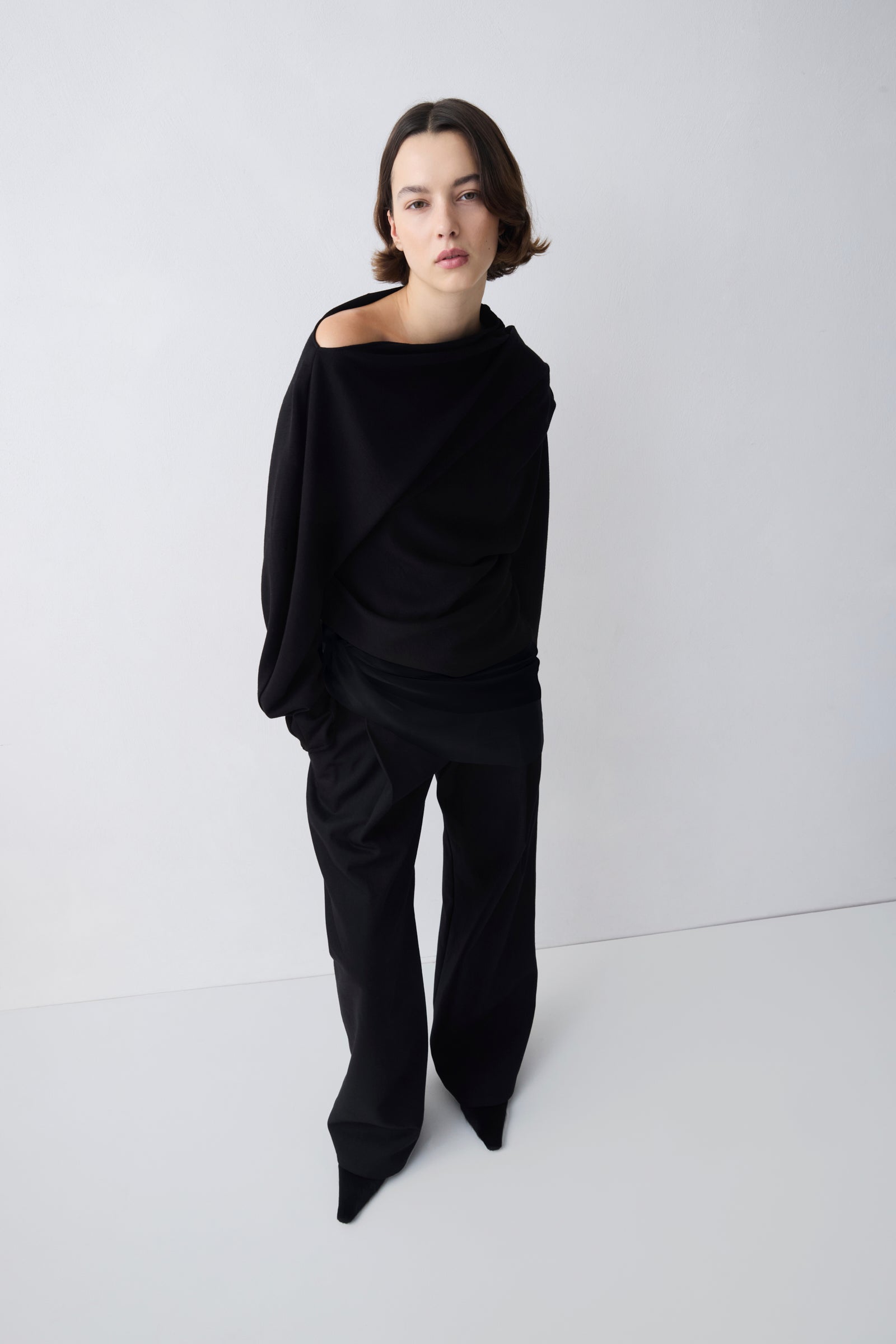 Person wearing a black outfit on a white background