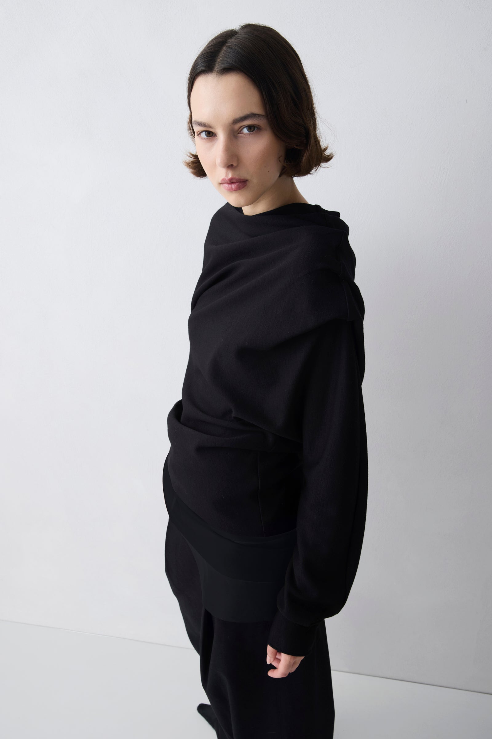Person wearing a black outfit against a white background