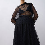 Woman wearing a black lace top against a white background