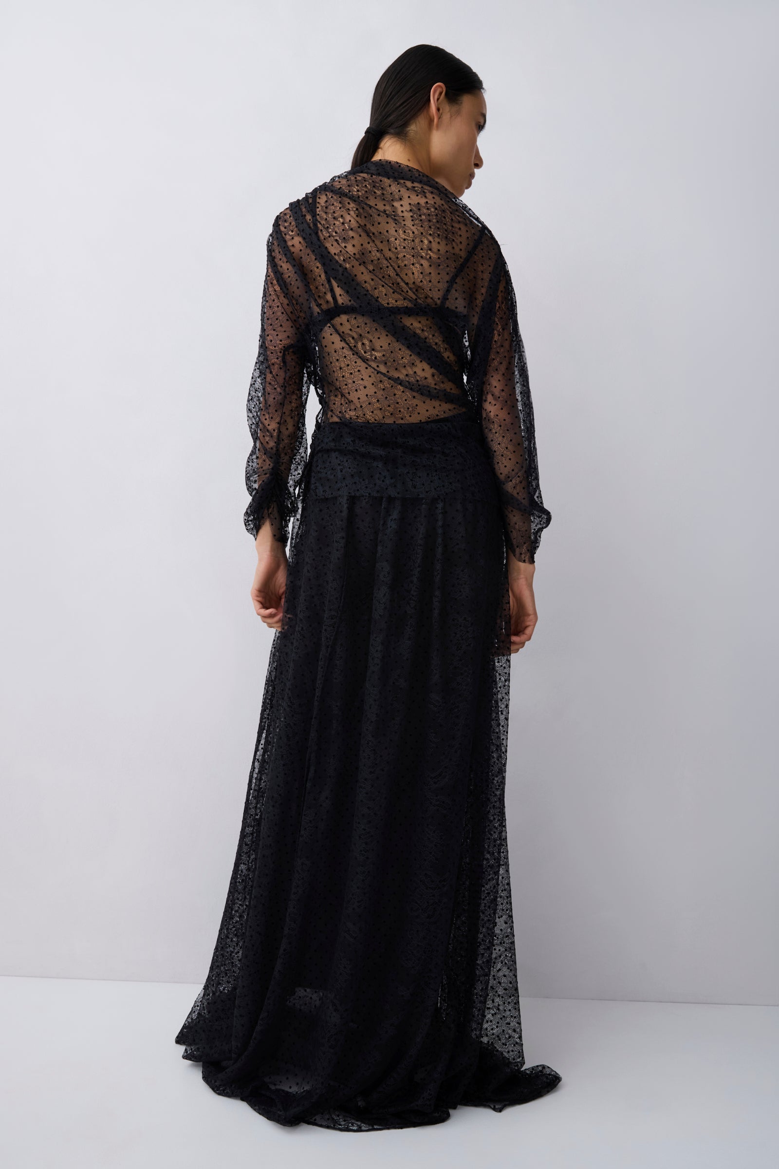 Woman wearing a black lace outfit on a white background
