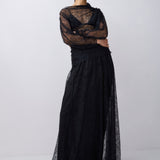 Model wearing a black lace outfit on a white background