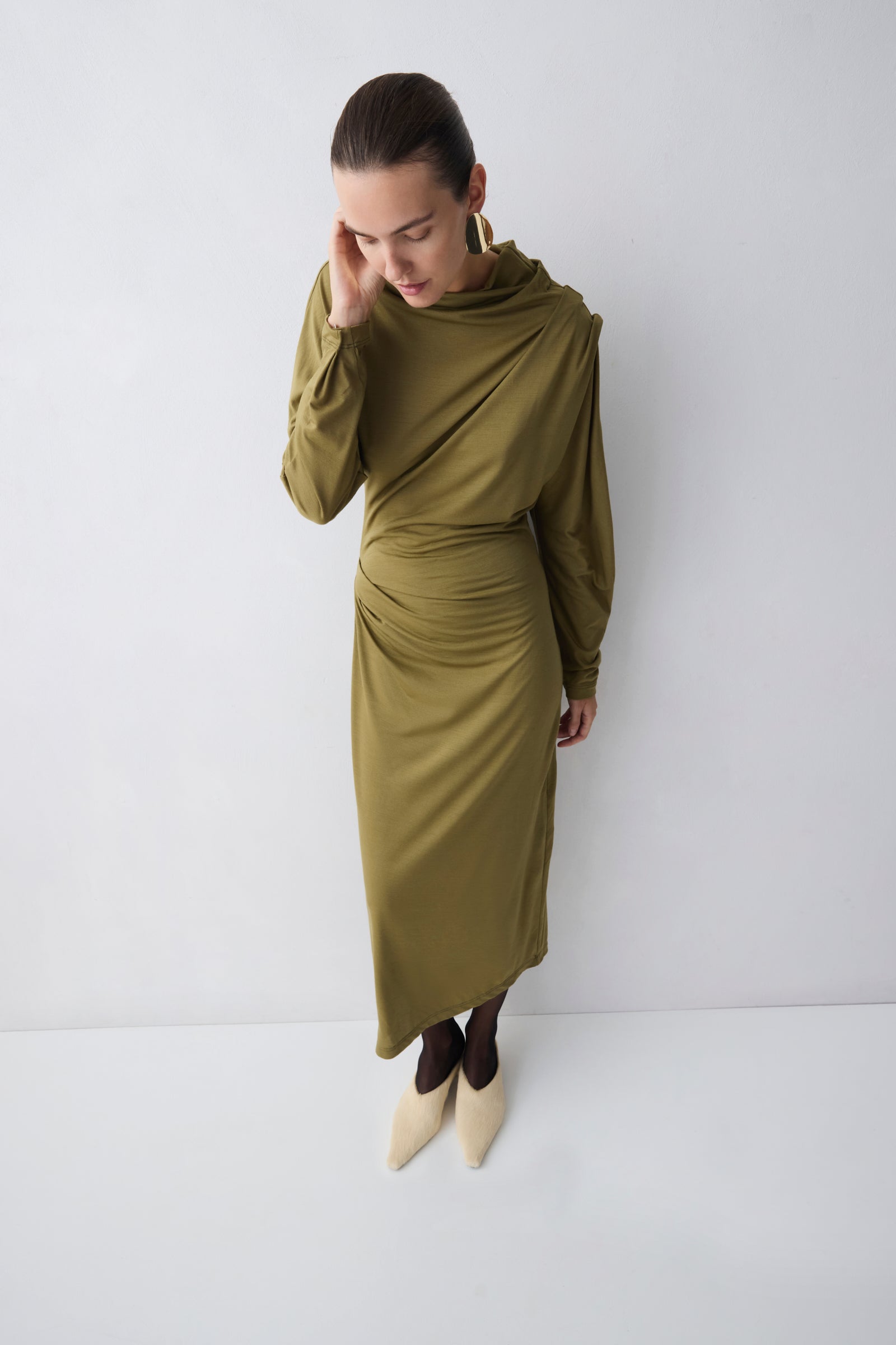 Woman wearing a green dress against a white background