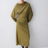 Woman wearing a green dress against a white background