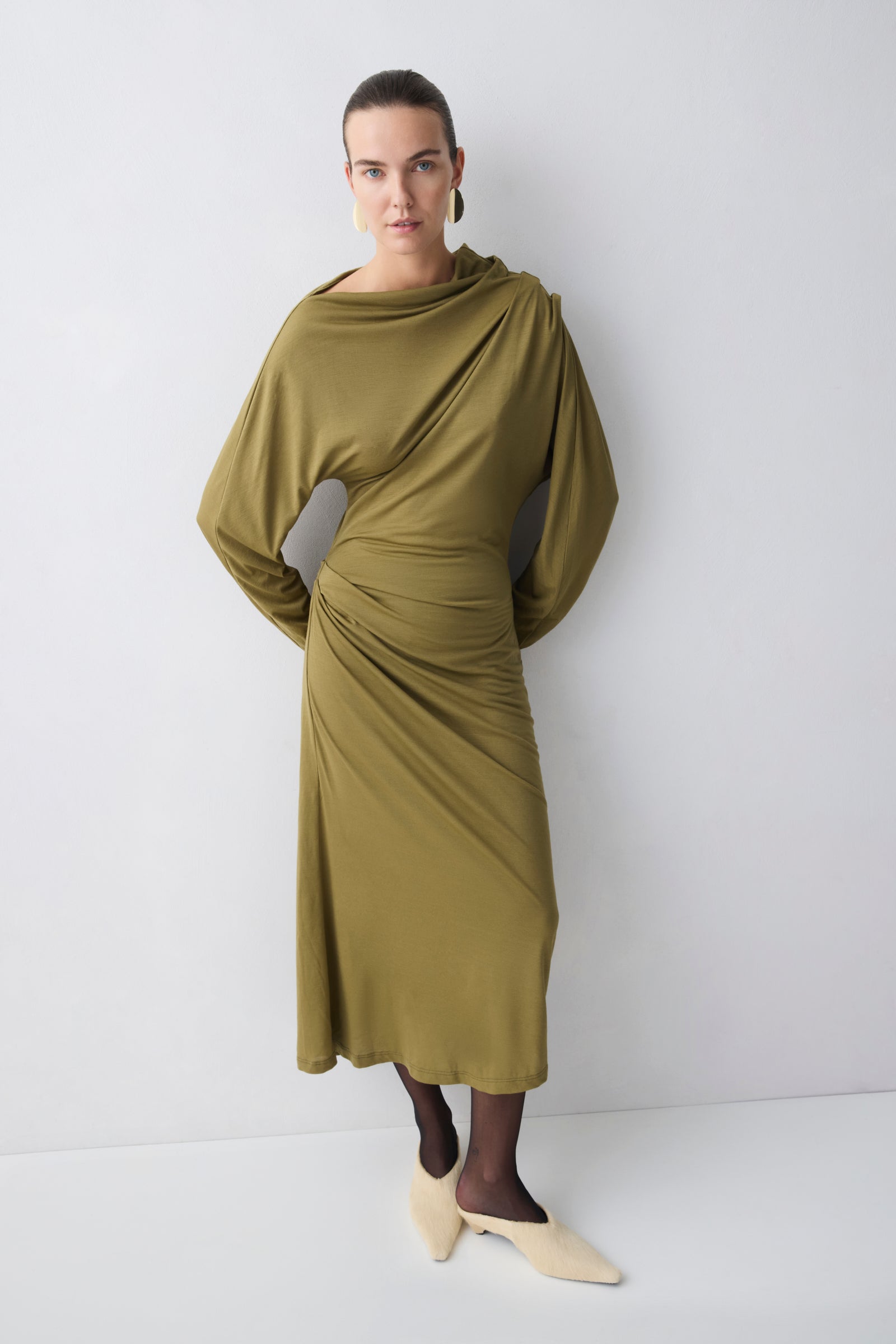 Woman wearing a green dress against a white background