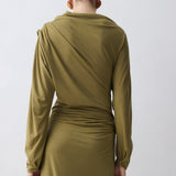 Person wearing a green dress with long sleeves on a white background