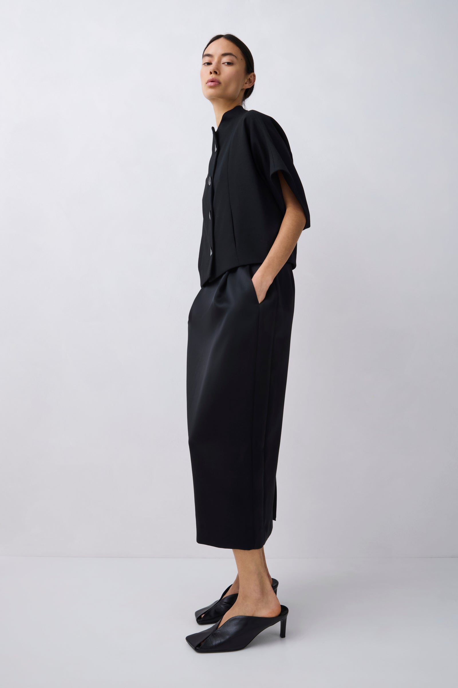 Person wearing a black outfit on a white background