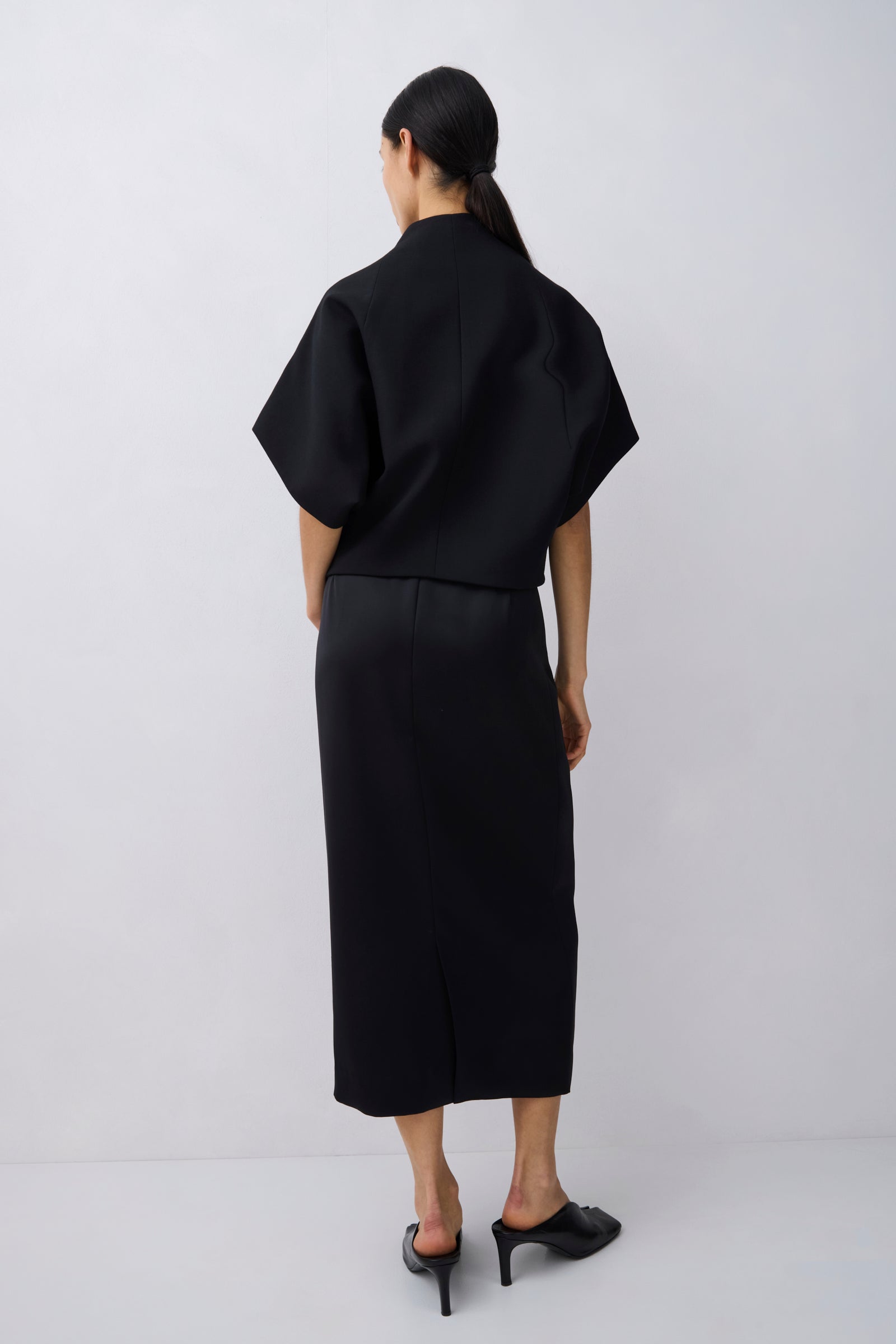 Person wearing a black outfit on a white background