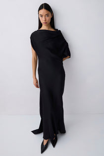 Woman wearing a black one-shoulder dress against a white background