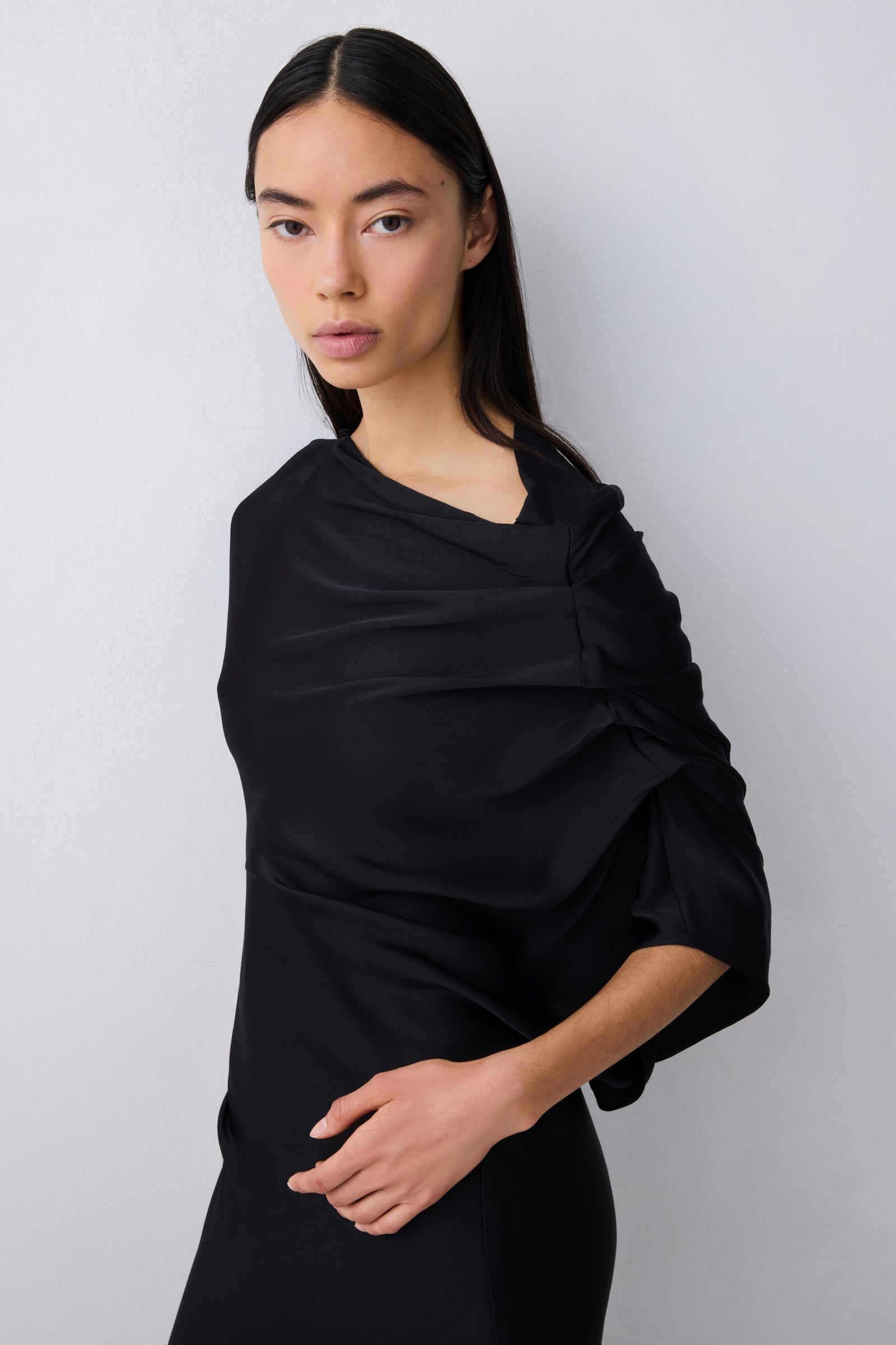 Woman wearing a black shawl against a white background