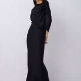 Woman wearing a black dress with a draped effect on a white background