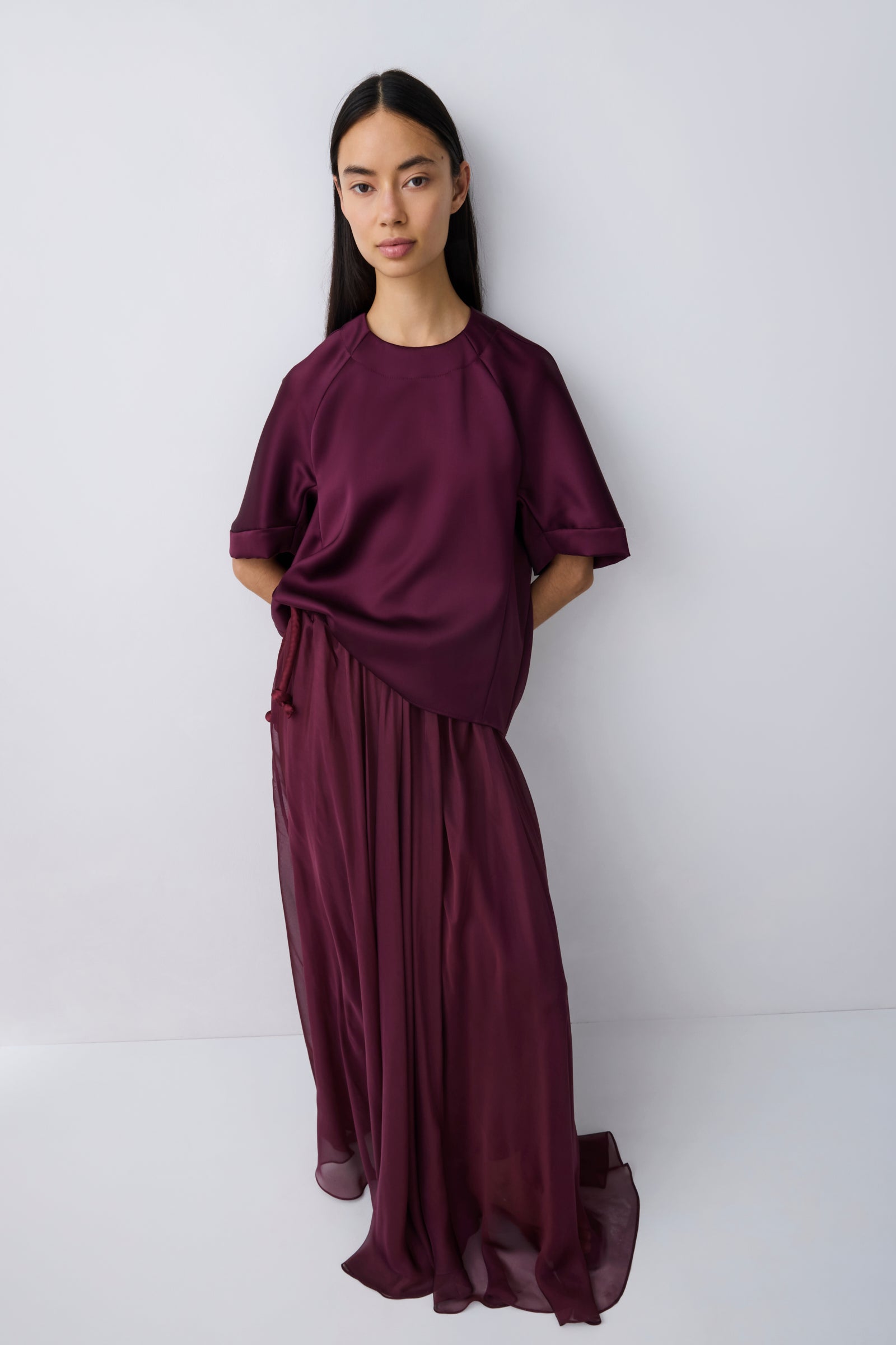 Woman wearing a burgundy outfit against a white background