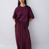 Woman wearing a burgundy outfit against a white background