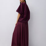 Woman wearing a burgundy dress against a white background