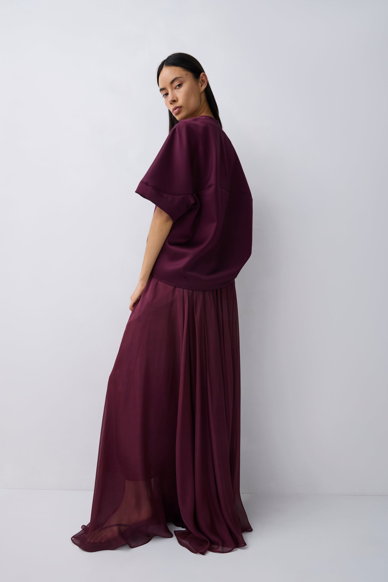 Woman wearing a burgundy dress against a white background