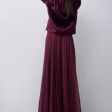 Woman wearing a long burgundy dress against a white background