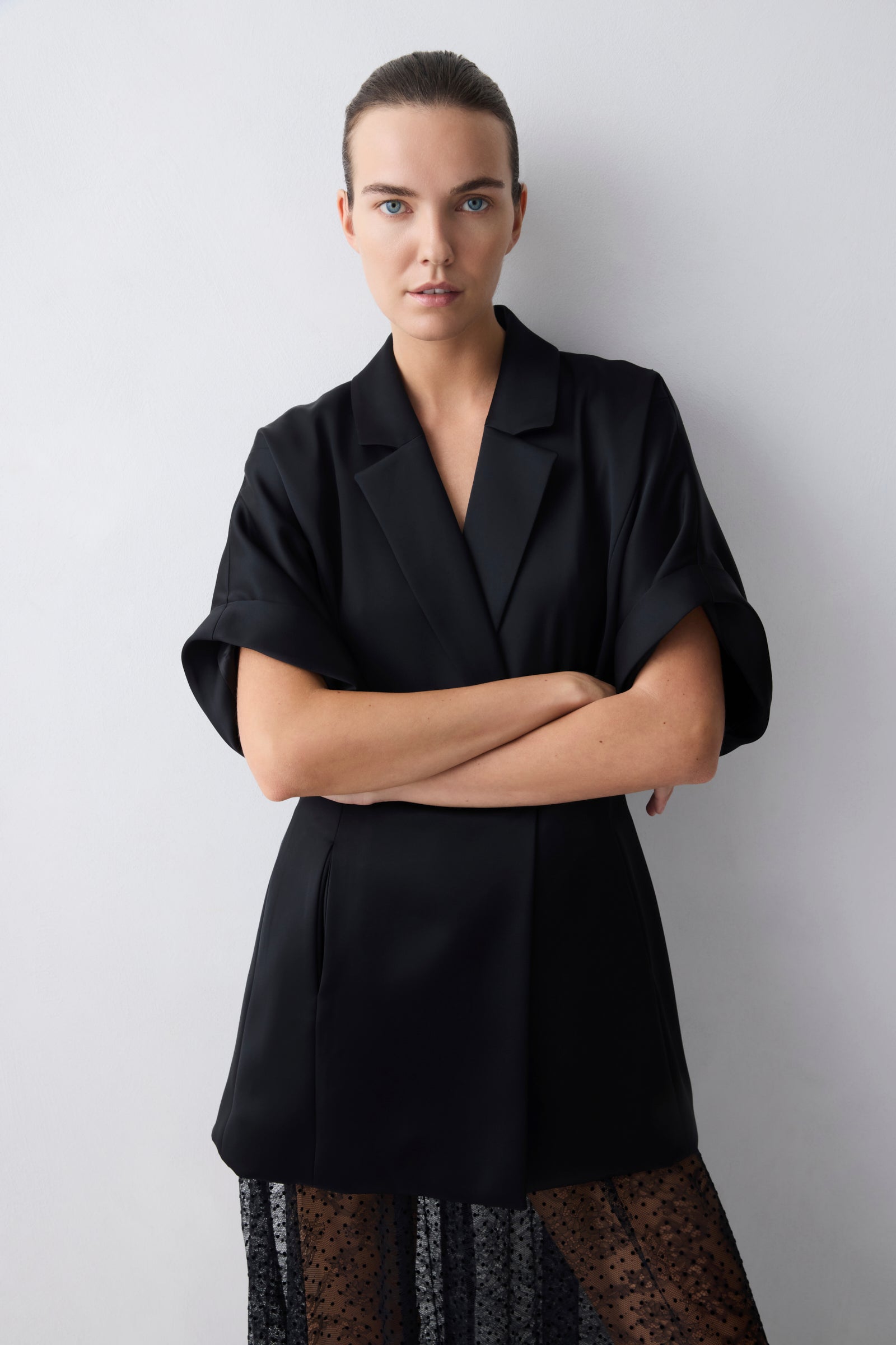 Woman wearing a black coat with a plain background