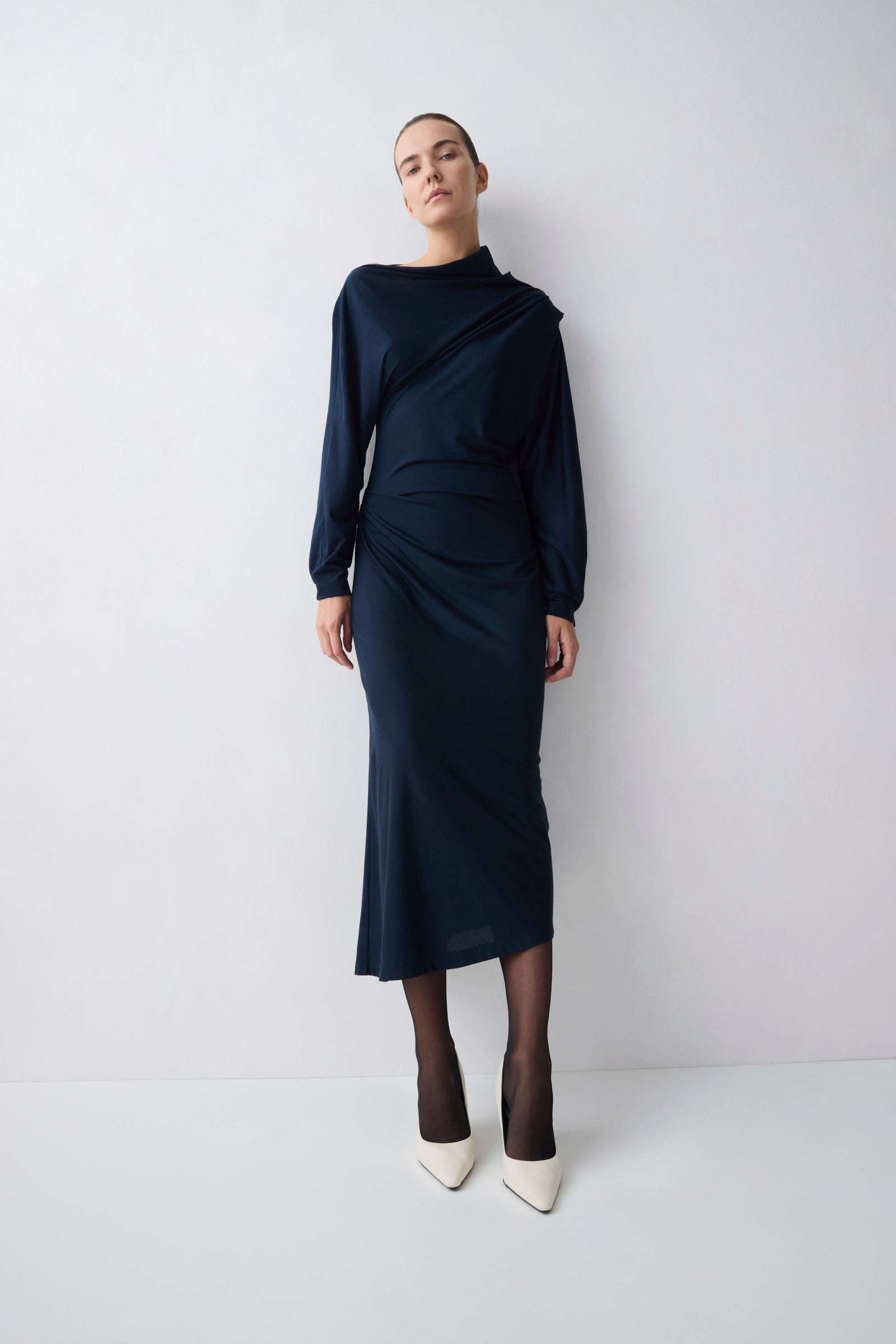 Person wearing a navy blue outfit on a white background