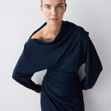 Woman wearing a navy blue dress against a white background