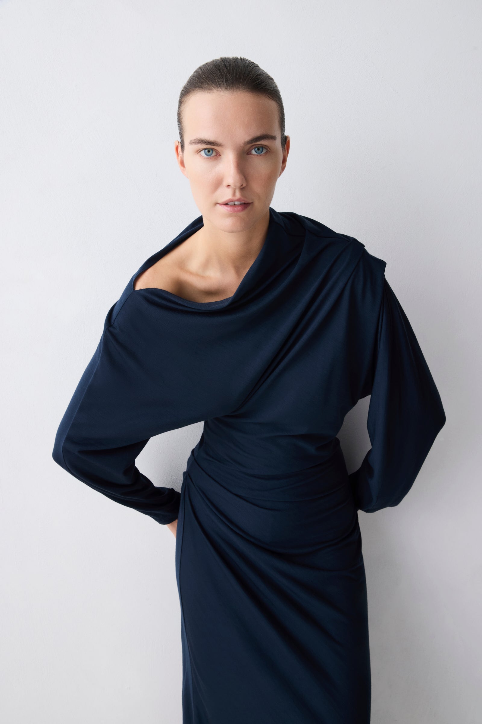 Woman wearing a navy blue dress against a white background